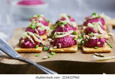 
Beetroot and feta cheese paste for a sandwich. Mini cracker sandwiches with beetroot spread. A light and healthy snack. Beet hummus.