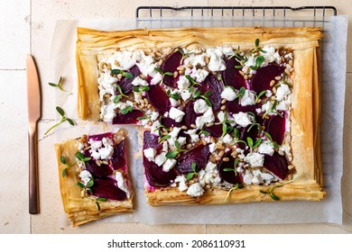 Beetroot and feta filo pizza. Beet Tart with feta, caramelized onion, pine nuts, sunflower micro greens and phyllo dough. Savoury vegetable vegetarian baking. 
