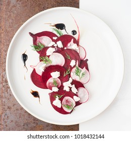 Beetroot feta salad fine dining with balsamic dressing and dill on ceramic white plate