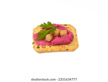Beetroot hummus spread on a cracker isolated on white background 