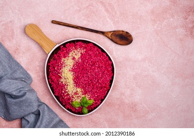 Beetroot risotto with cheese in a ceramic dish on a cement background. Top view. Selective focus.