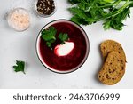 beetroot soup with vegetables. delicious borscht with sour cream, green parsley, garlic on the white background. top view. Traditional Russian and Ukrainian dish