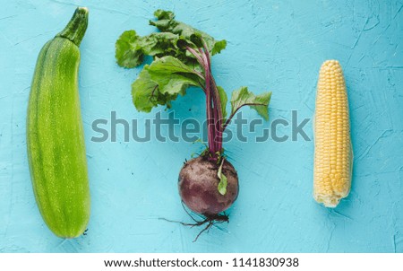 Beetroot, zucchini and corn on blue background