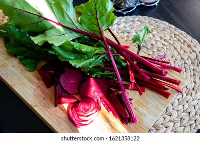 Beets With Green Leaves On Cutting Board On Table