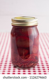 Beets on a Red Gingham Table Cloth in a Home Canning Jar