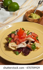 Beets And Parsnip Chip Nachos With Shredded Chicken On A Yellow Plate And A Wood Bowl Of Lime Avocado Paste