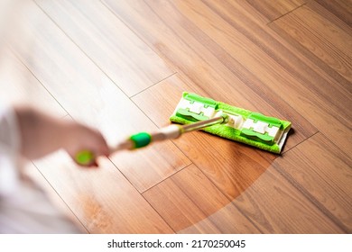 before and after cleaning concept - woman cleaning wooden floor with mop in living room - Shutterstock ID 2170250045