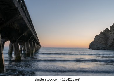 Before Dawn With The Sky Lighting Up In The Gap Between The Wharf And The Cliff