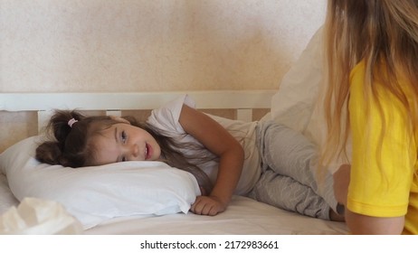 Before go to night or daytime sleep mother reading to daughter fairytale, kid enjoy storytelling lying with mommy in bed feels comfortable, good pastime develop reader skill, have fun at home concept.
