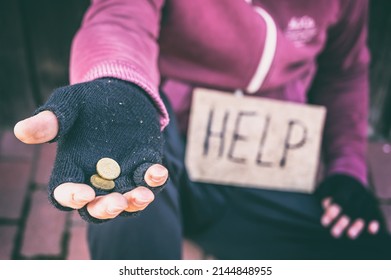 Begging Hand With Single Coins And Cardboard Sign With Inscription Help