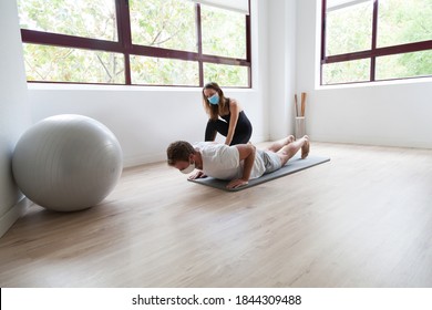 Beginner Yogi And His Coach Practicing Yoga Wearing Protective Mask During Covid-19