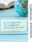 In the beginning God created heavens and earth, handwritten quote with world globe and holy bible book in the background. Close-up. Christian biblical concept of creation.