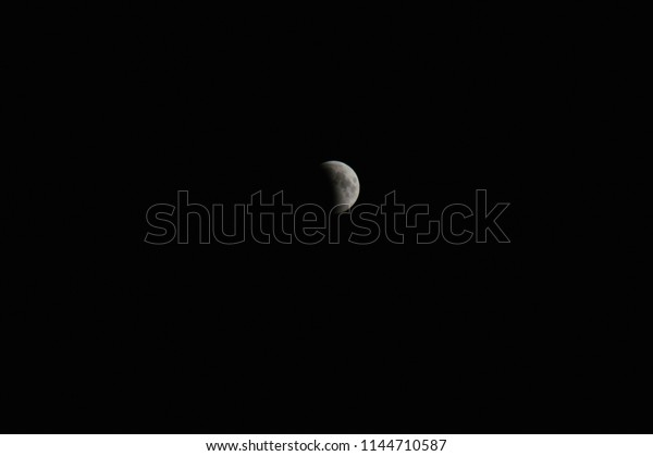 The beginning of a lunar eclipse against the\
background of the night sky