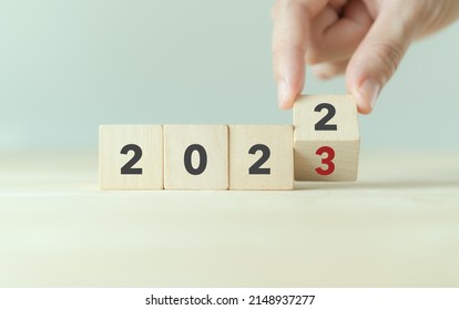 Beginning and start of the new year 2023. Preparation for happy new year ,new life, new business, plan, goals, strategy concept. Hand flips wooden cubes with  2022 to 2023 on smart background.  - Shutterstock ID 2148937277