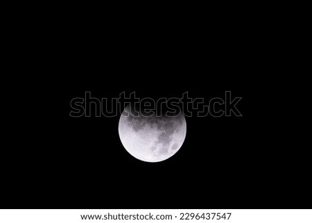 The beginnings of a total lunar eclipse on a new full moon night as the earth's shadow passes in front of its lone satellite 