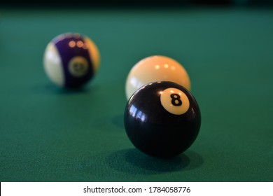 Behind the 8 ball cue ball and 8 ball on a green felt pool table. Pool  is applied physics of force and vectors.
