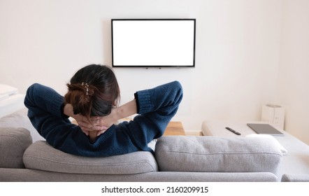 Behind Of Asian Young Woman Watching White Screen TV On The Sofa At Home