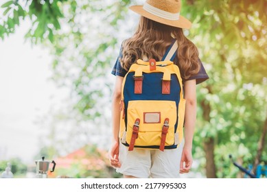 Behind The Female Tourist Carrying A Yellow Bag.