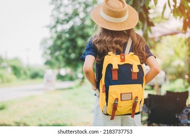 Behind The Female Tourist Carrying A Yellow Bag.