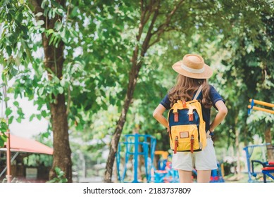 Behind The Female Tourist Carrying A Yellow Bag.