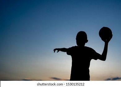 Behind Kids Holding American Football And Throwing On Sky Background, Dark Black Shadow 