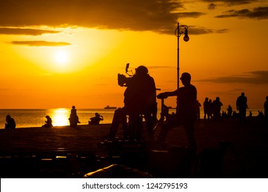 Behind the scene. Film crew team filming movie scene on outdoor location at sunset. Trieste