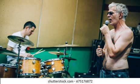 Behind The Scene. Rock Band Practice In The Messy Recording Music Studio. Alternative Musician Group Live Playing