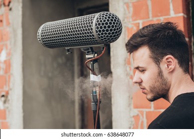 Behind The Scene. Sound Boom Operator Resting On The Set And Hold Microphone Fisher Outdoor