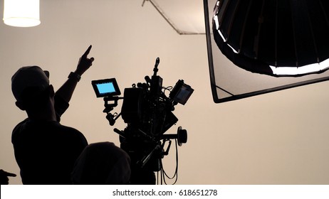 Behind the scene of tv movie video film shooting production crew team and camera lighting set in the big studio.