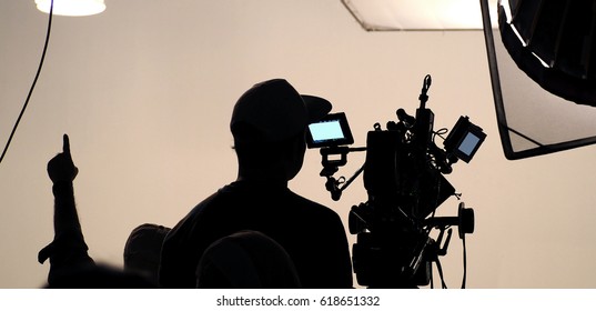 Behind the scene of tv movie video film shooting production crew team and camera lighting set in the big studio.