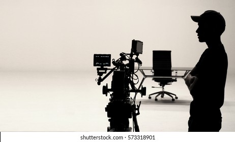 Behind the scenes or making of film in the studio and silhouette of camera man.