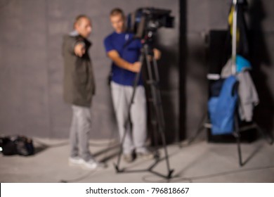 Behind the scenes or making of film in the studio and silhouette of cameraman, blurred image. blur image of group of stage staff for background usage. Video camera is ready to record.