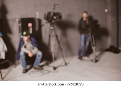 Behind the scenes or making of film in the studio and silhouette of cameraman, blurred image. blur image of group of stage staff for background usage. Vintage photo processing