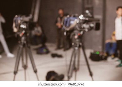 Behind the scenes or making of film in the studio and silhouette of cameraman, blurred image. blur image of group of stage staff for background usage. Vintage photo processing