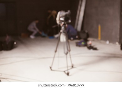Behind the scenes or making of film in the studio and silhouette of cameraman, blurred image. blur image of group of stage staff for background usage. Vintage photo processing