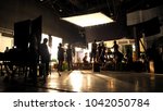 Behind the scenes or the making of film video production and movie crew team working in silhouette of camera and equipment set in studio. 