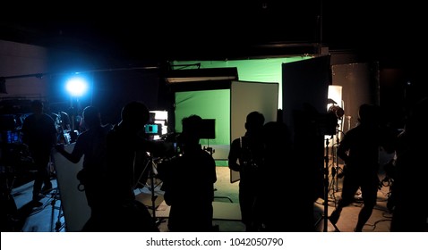 Behind The Scenes Or The Making Of Film Video Production And Movie Crew Team Working In Silhouette Of Camera And Equipment Set In Studio. 