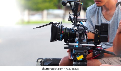 Behind The Scenes Of Movie Or Video Shooting Production Camera Set And Film Crew At Outdoor Location.