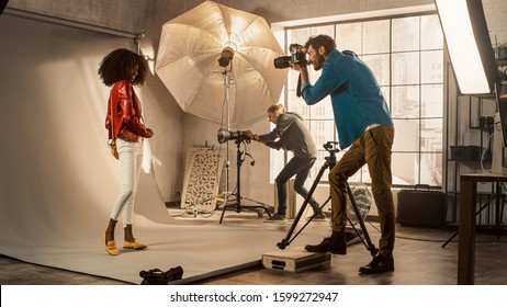 Behind the Scenes on Photo Shoot: Beautiful Black Model Posing for a Photographer, he Takes Photos with Professional Camera. Stylish Fashion Magazine Photoshoot with Pro Equipment in a Studio - Shutterstock ID 1599272947