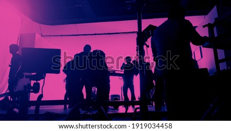 Behind the scenes of shooting video production and lighting set for filming movie which film crew team working in silhouette and professional equipment in studio for video. video production concept.