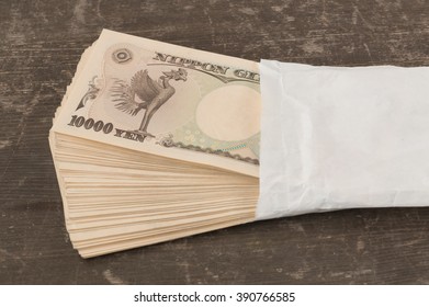 Behind Side Of Ten Thousand Yen Japanese Money In White  Envelope On Table