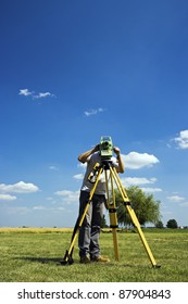 Behind Theodolite - land surveying in rural area.