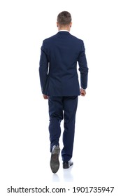 Behind View Of Elegant Young Man In Navy Blue Suit Walking Isolated On White Background In Studio