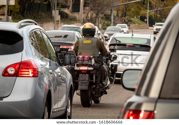 Behind\
view of motorcycle police offcier in dense\
traffic