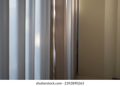 beige background with light and shadow of window curtains