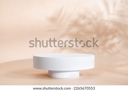 Beige background  for product presentation with shadow of tropical palm leaves and light. Podium, stage pedestal  platform for cosmetic product. Empty round podium. Mockup.