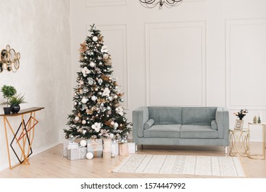 Beige and blue room with Christmas and New Year decorated interior. Christmas tree with gifts in a light interior of the house.