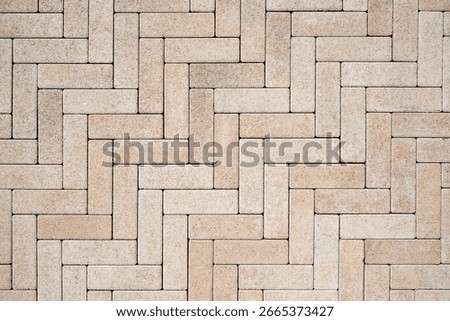 Beige brick paving pattern in herringbone style. Geometric pavement design for modern urban spaces. Architectural background.