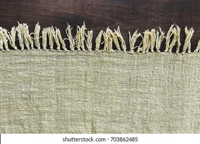 Beige Carpet With Fringe On Dark Wooden Floor, Texture Close Up