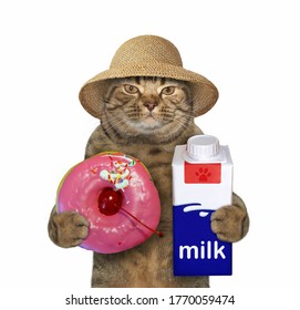 The Beige Cat In A Straw Hat Is Holding A Pink Donut With A Cherry Inside It And A Milk Carton Box. White Background. Isolated.